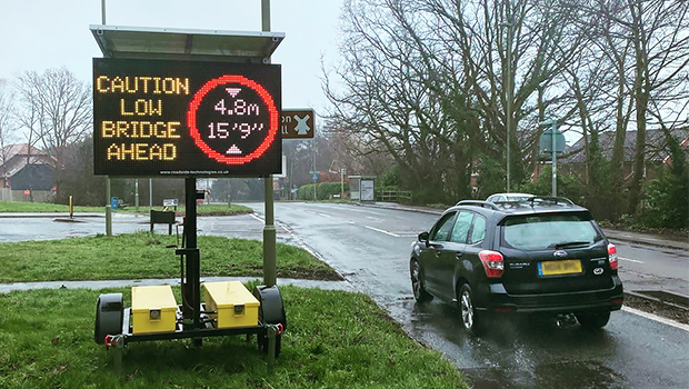 A VMS showing a low bridge alert and bridge height warning